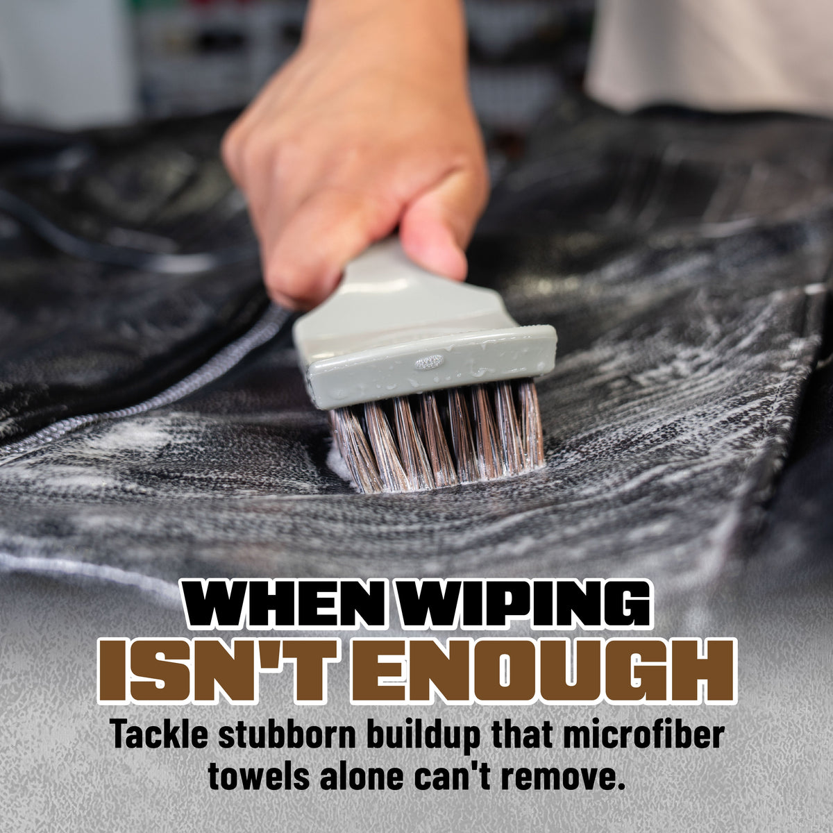 Nifty Leather Cleaning Brush scrubbing black leather upholstery - when wiping isn't enough, tackle stubborn buildup that microfiber towels alone can't remove